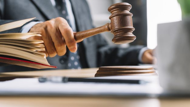 close-up-male-judge-s-hand-striking-gavel-table_23-2147898505