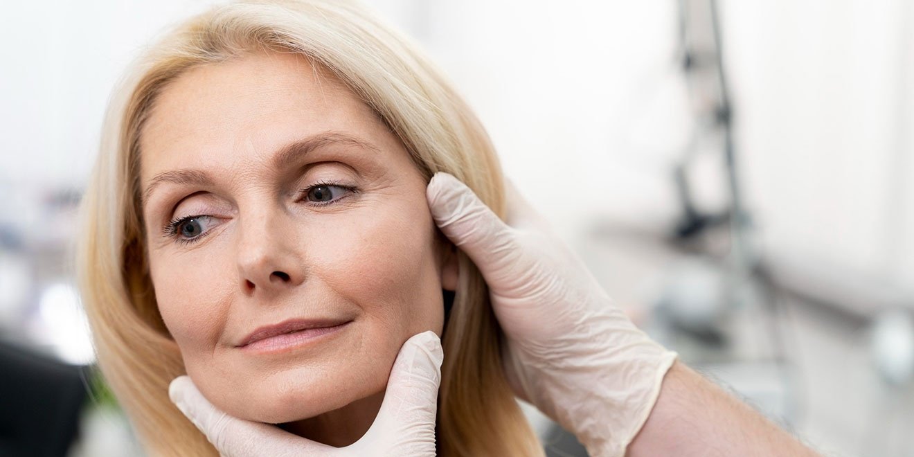 Patient's cheekbone and jawline being examined for facial implant or filler.