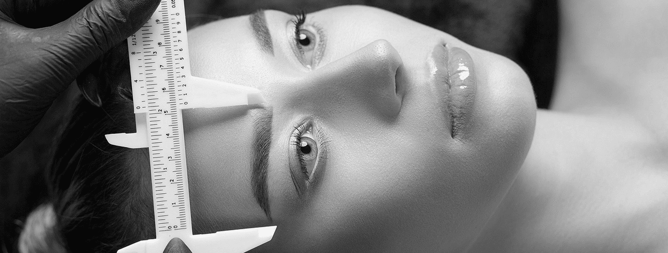 Precise measurement with calipers to determine facial proportions and symmetry before brow lift surgery