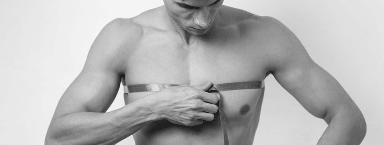 Man measuring chest area with tape for pre-operative planning of pectoral implant (male chest augmentation) surgery.