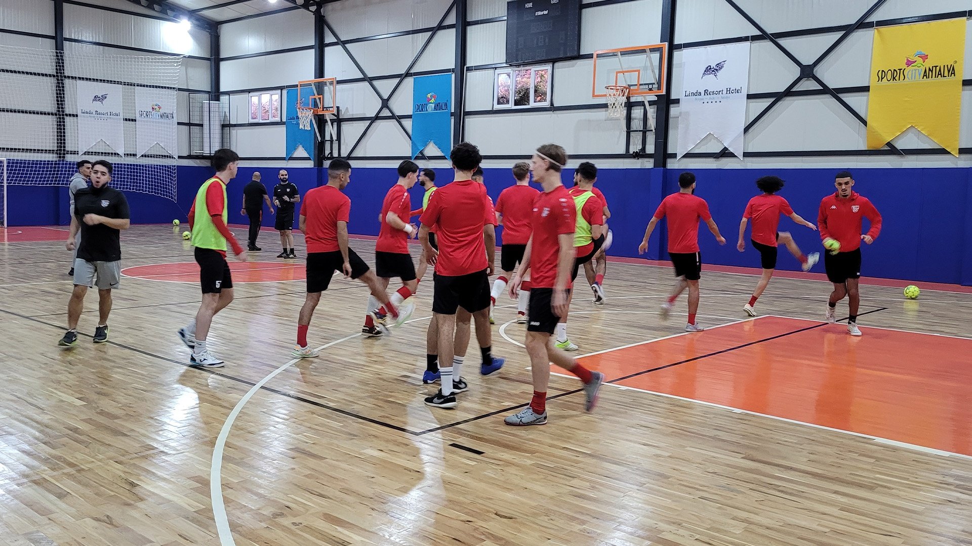 Futsal players developing technical skills on an indoor court
