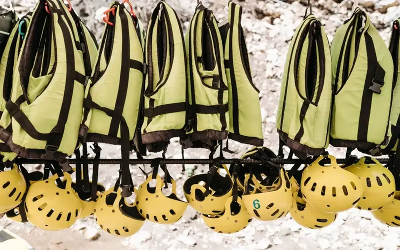 Life jackets and helmets hanging ready for a rafting trip