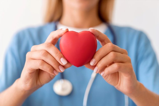 defocused-female-doctor-holding-heart-shape