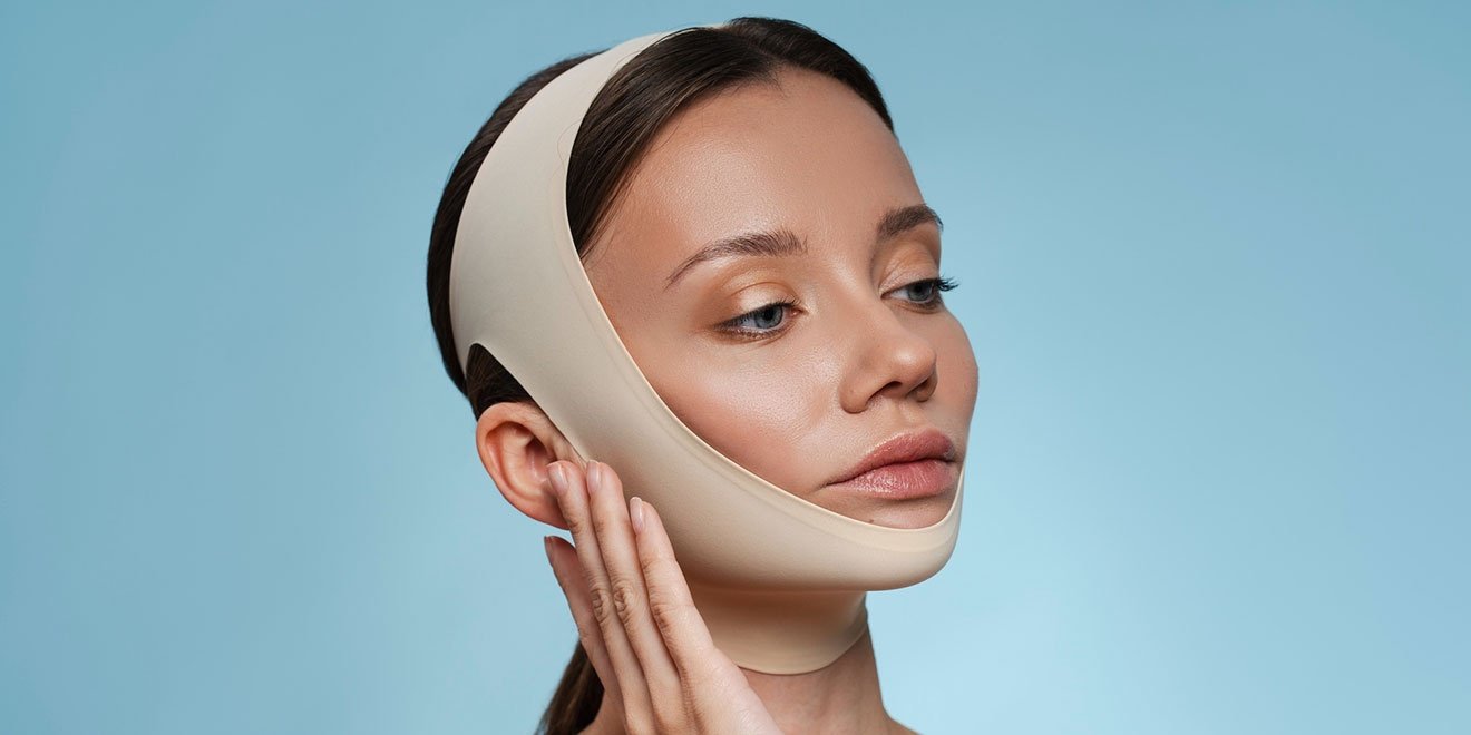 Woman wearing a facelift recovery compression garment during the healing process