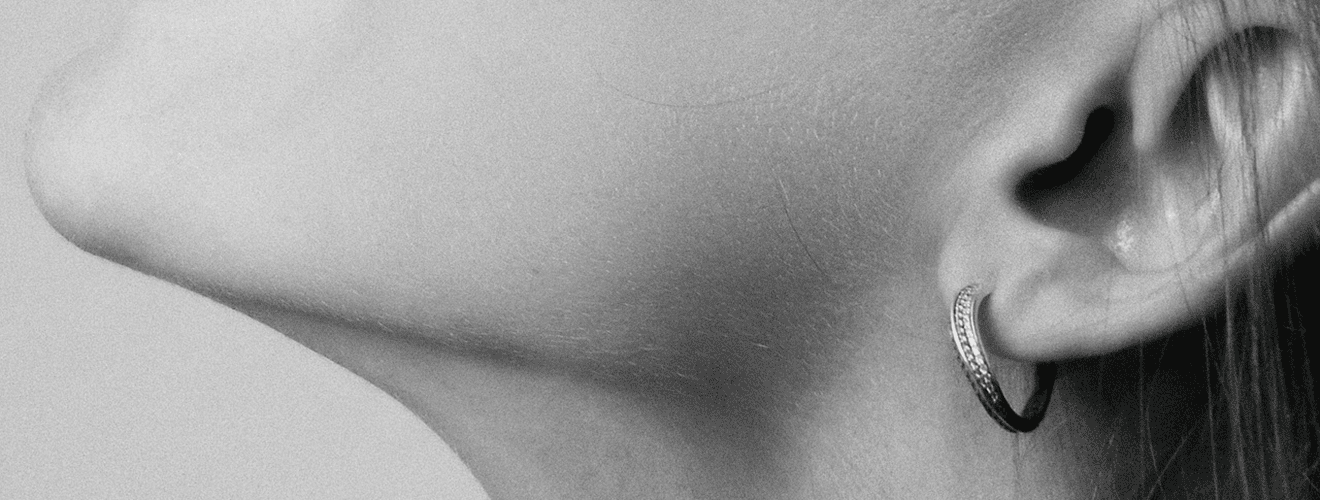 Close-up profile of a woman showing a defined jawline and earlobe with an earring.