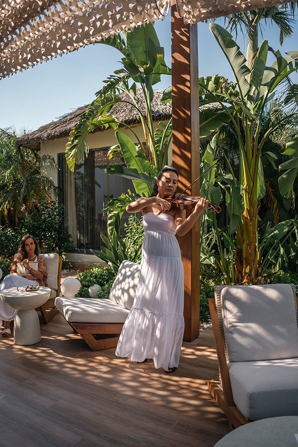 The woman playing the violin in the paradise garden of Q Spa & Wellness