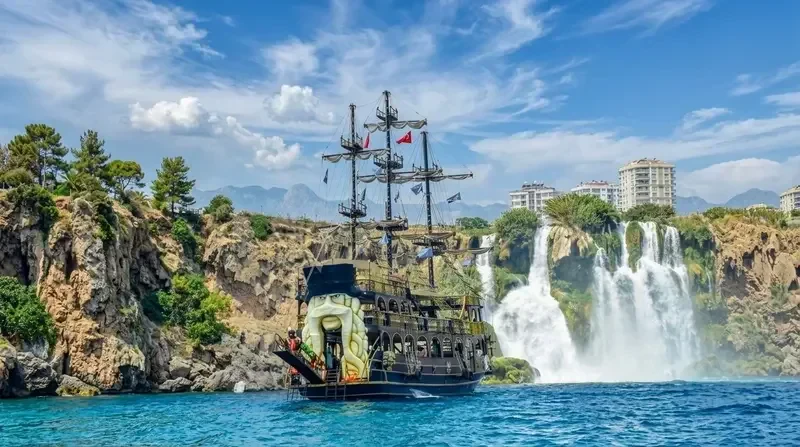 Pirate boat tour passing the Düden waterfall cliffs in Antalya