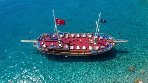 Лодка с местами для загара в бирюзовой воде, вид сверху, Анталия